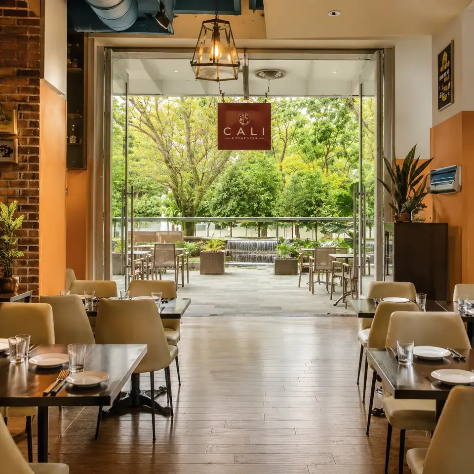 Glass-walled dining room opening onto the sheltered alfresco at CALI Rochester Park